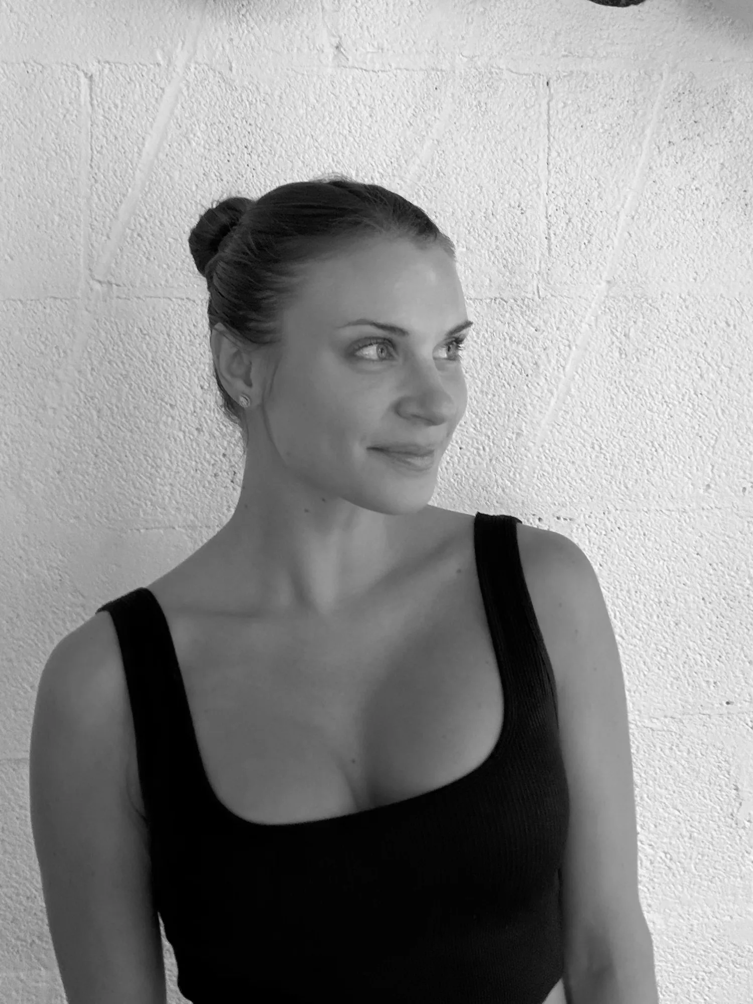Ashley Rose, Pilates instructor, black and white portrait against a textured wall