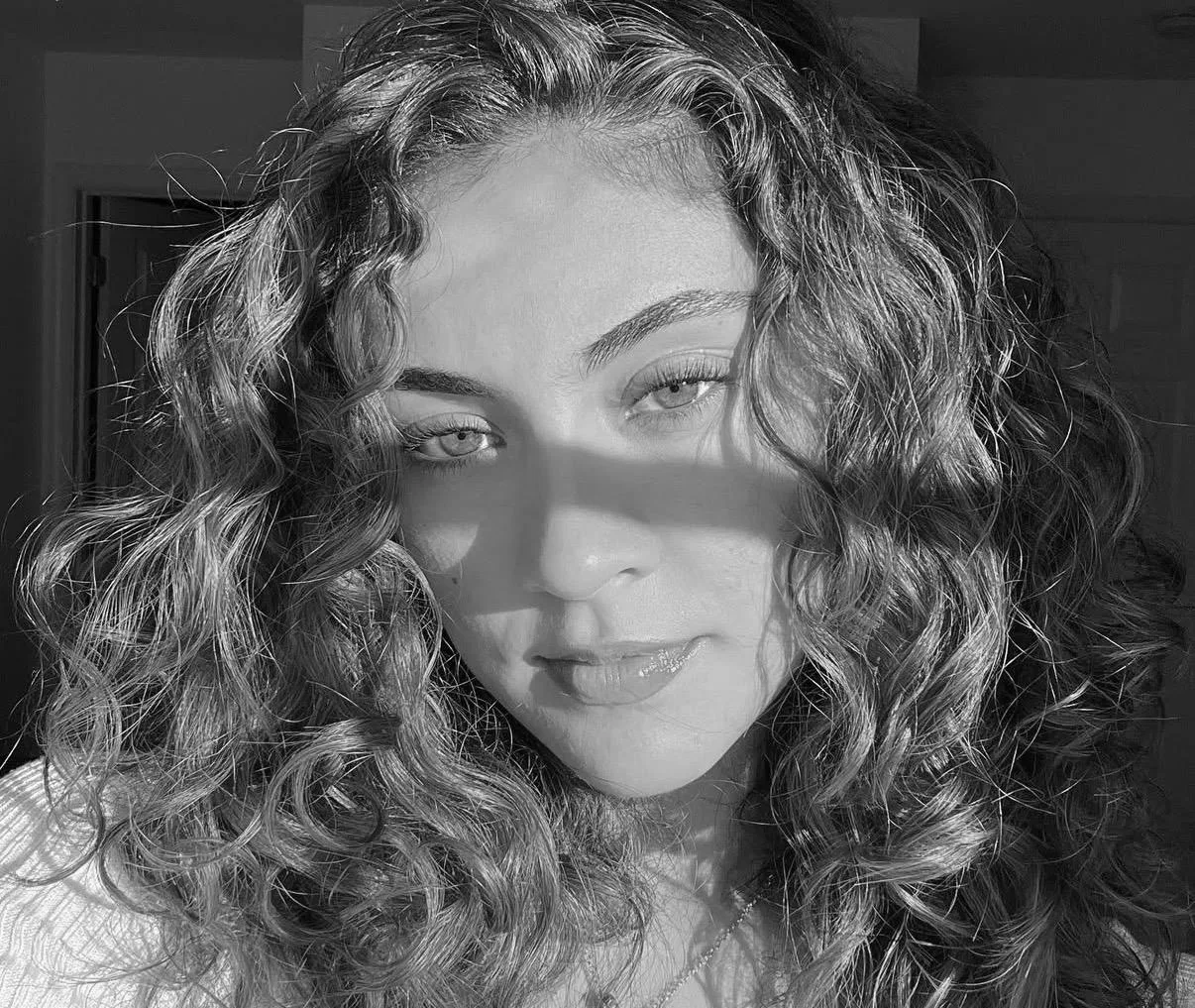 Gaby Fernandez, Pilates instructor, black and white close-up portrait with curly hair